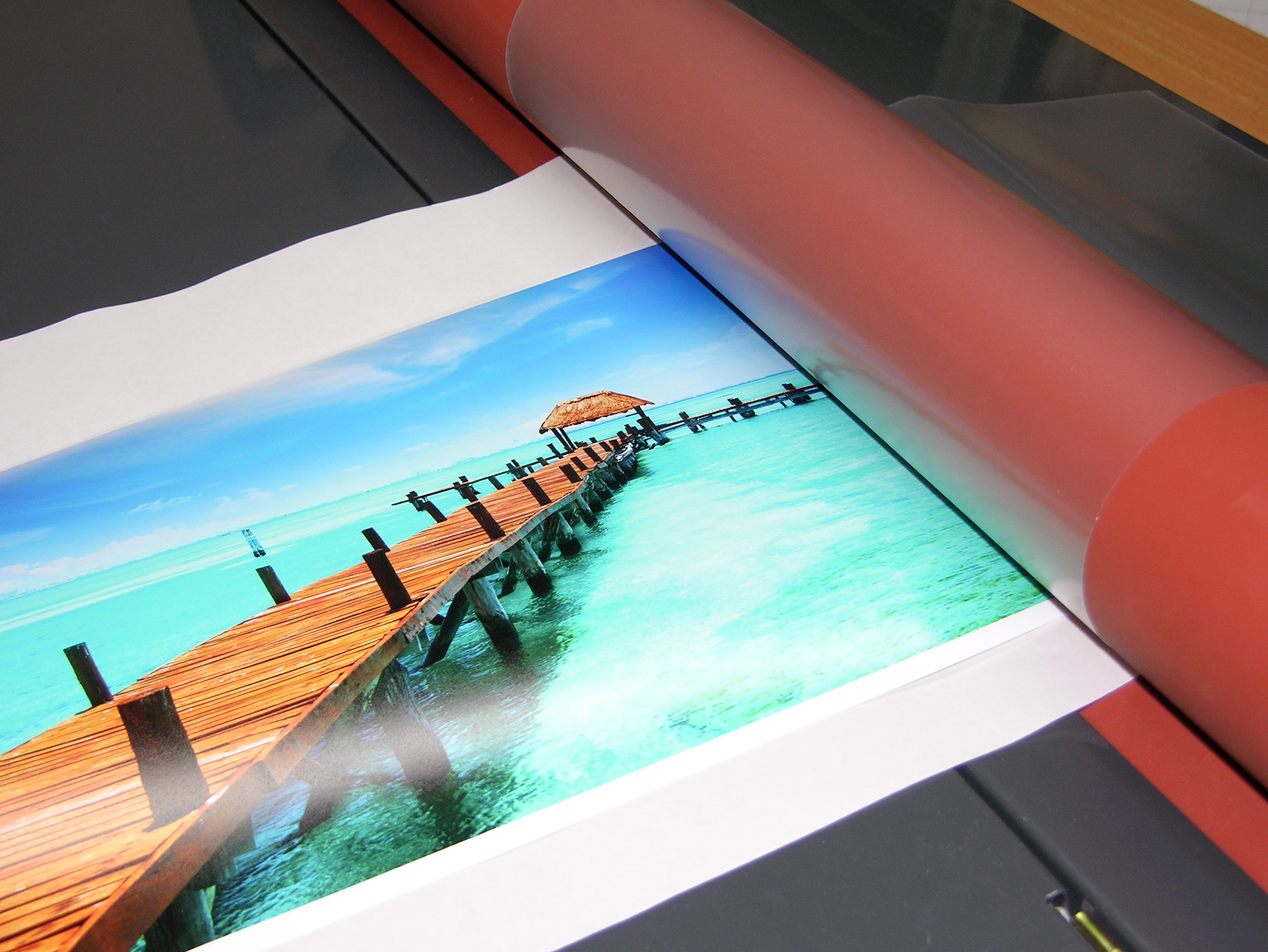 laminování potištěného fotopapíru při výrobě fotoobrazu na desce